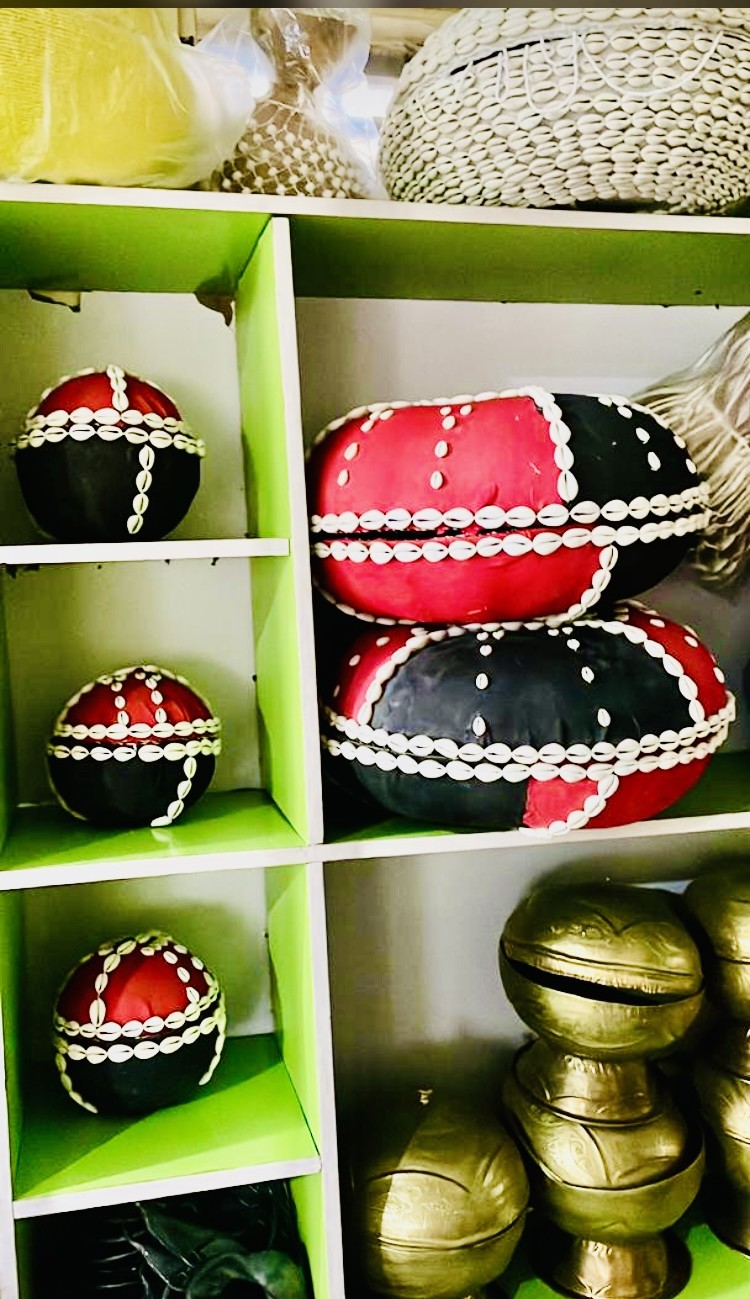 Cowrie-adorned ritual pots and brass vessels on display